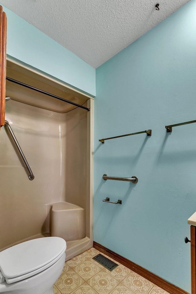 bathroom featuring a textured ceiling, toilet, and vanity