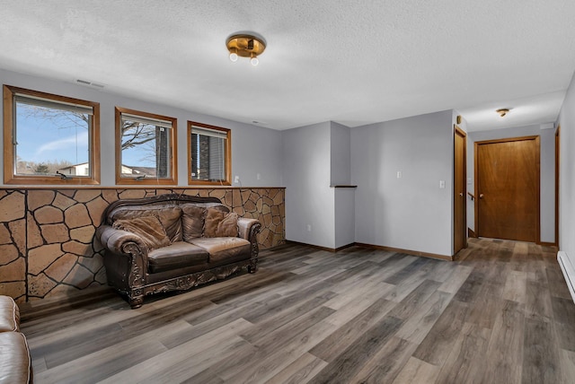 unfurnished living room with a textured ceiling and hardwood / wood-style flooring