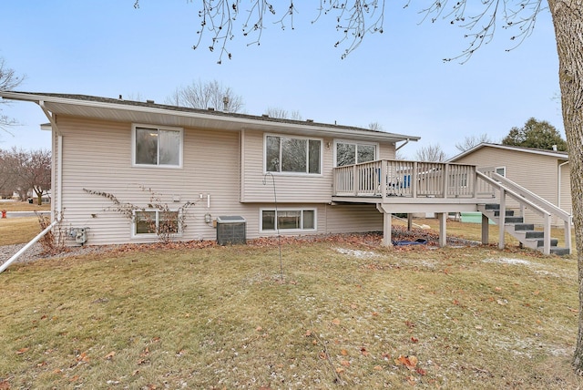 back of house featuring a deck, a lawn, and central AC