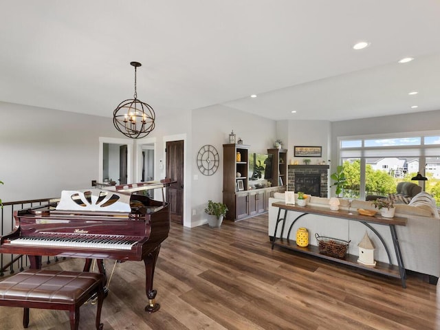 miscellaneous room with a fireplace, a chandelier, and hardwood / wood-style flooring