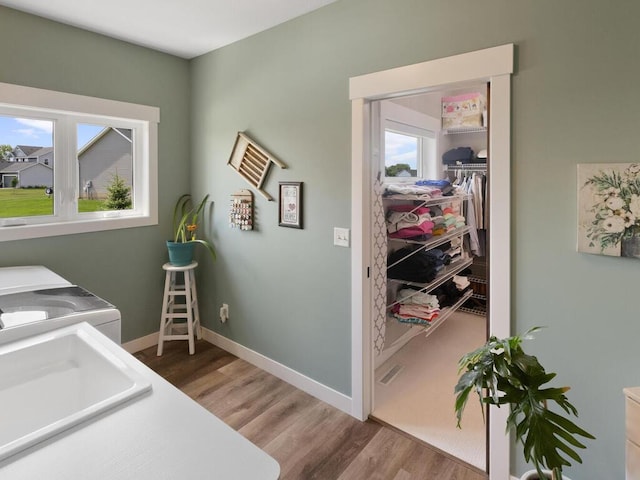 laundry area with sink, light hardwood / wood-style flooring, and washer and clothes dryer