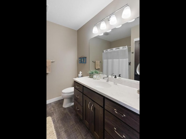 bathroom featuring toilet, hardwood / wood-style flooring, and vanity