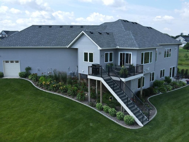 rear view of property featuring a garage, central AC, and a lawn