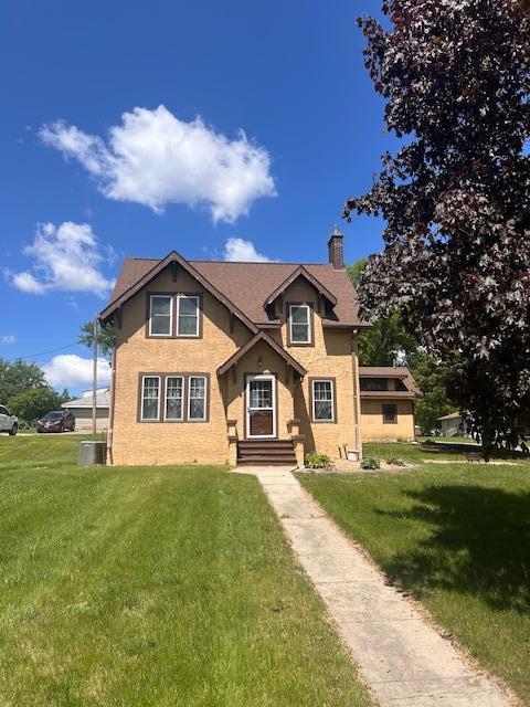 310 7th St, Starbuck, MN 56381 - traditional-style home with a chimney, a front yard, and central air condition unit