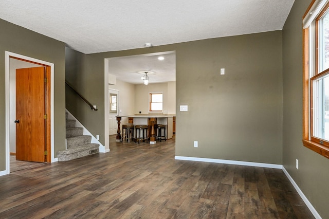 interior space featuring a textured ceiling and dark hardwood / wood-style floors