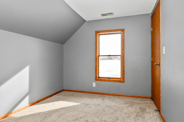 bonus room featuring lofted ceiling and light carpet