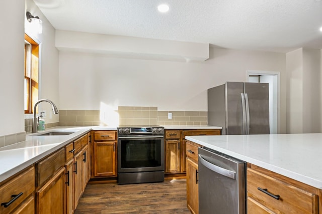 kitchen featuring stainless steel appliances, dark hardwood / wood-style flooring, sink, tasteful backsplash, and a textured ceiling