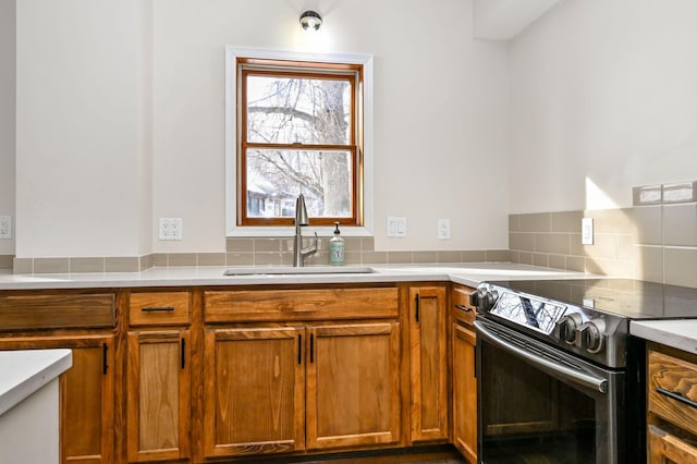 kitchen featuring sink, stainless steel electric range, and decorative backsplash