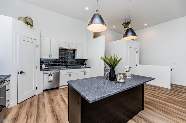 kitchen featuring hanging light fixtures, white cabinets, stainless steel appliances, and a kitchen island