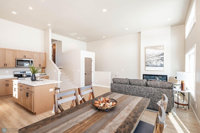 131 Pine Ave, Mapleton, ND 58059 - dining room featuring light wood finished floors, stairway, recessed lighting, baseboards, and a glass covered fireplace