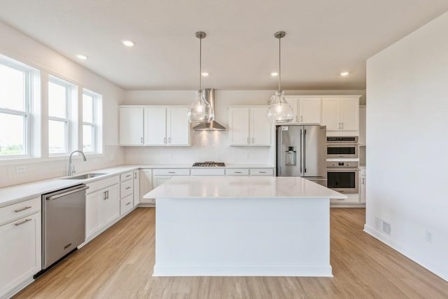 kitchen with a kitchen island, white cabinetry, sink, and appliances with stainless steel finishes