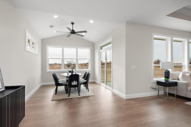 dining area with ceiling fan, a healthy amount of sunlight, lofted ceiling, and light hardwood / wood-style flooring