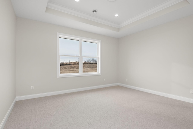 unfurnished room featuring carpet floors, a tray ceiling, and ornamental molding