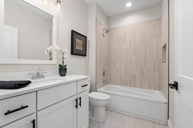 full bathroom featuring hardwood / wood-style floors, vanity, toilet, and tiled shower / bath