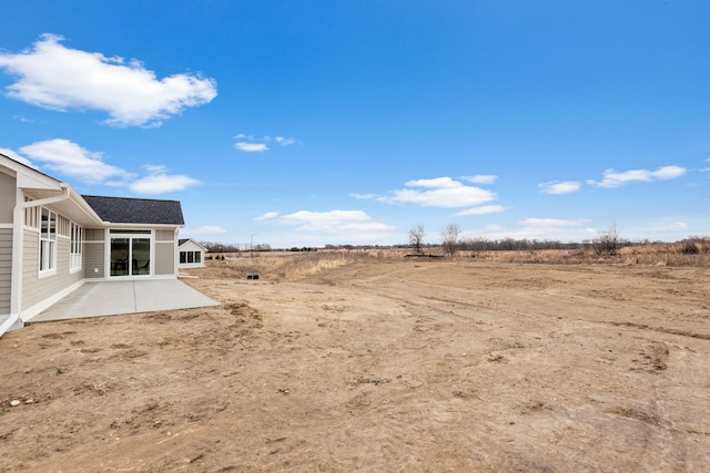 view of yard featuring a patio and a rural view