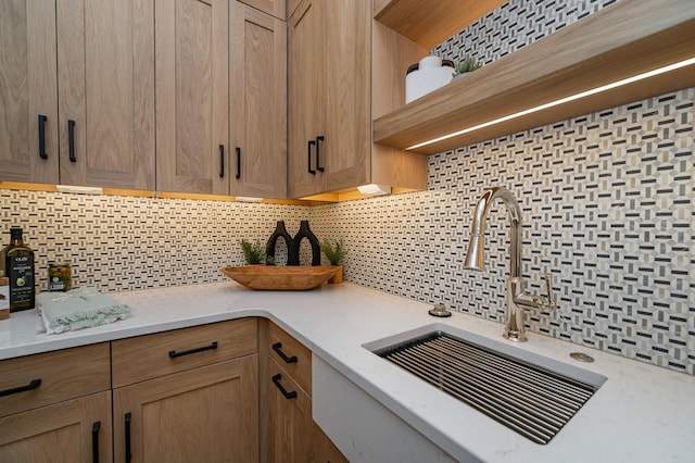 kitchen featuring open shelves, tasteful backsplash, and a sink