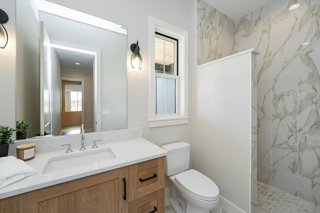 bathroom featuring toilet, vanity, and a walk in shower