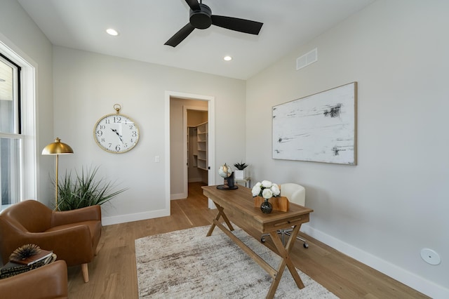 home office with visible vents, baseboards, wood finished floors, and a ceiling fan