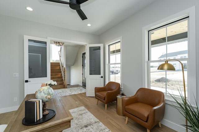 sitting room featuring stairway, recessed lighting, baseboards, and light wood-type flooring