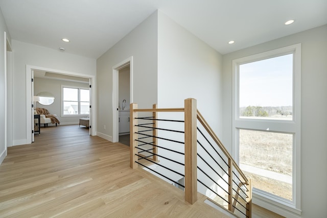 hall featuring recessed lighting, baseboards, an upstairs landing, and light wood-style flooring