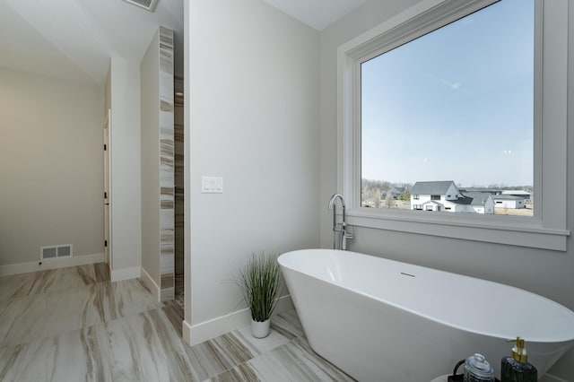 full bath with visible vents, baseboards, and a freestanding bath