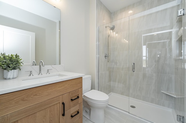 bathroom with a stall shower, toilet, and vanity