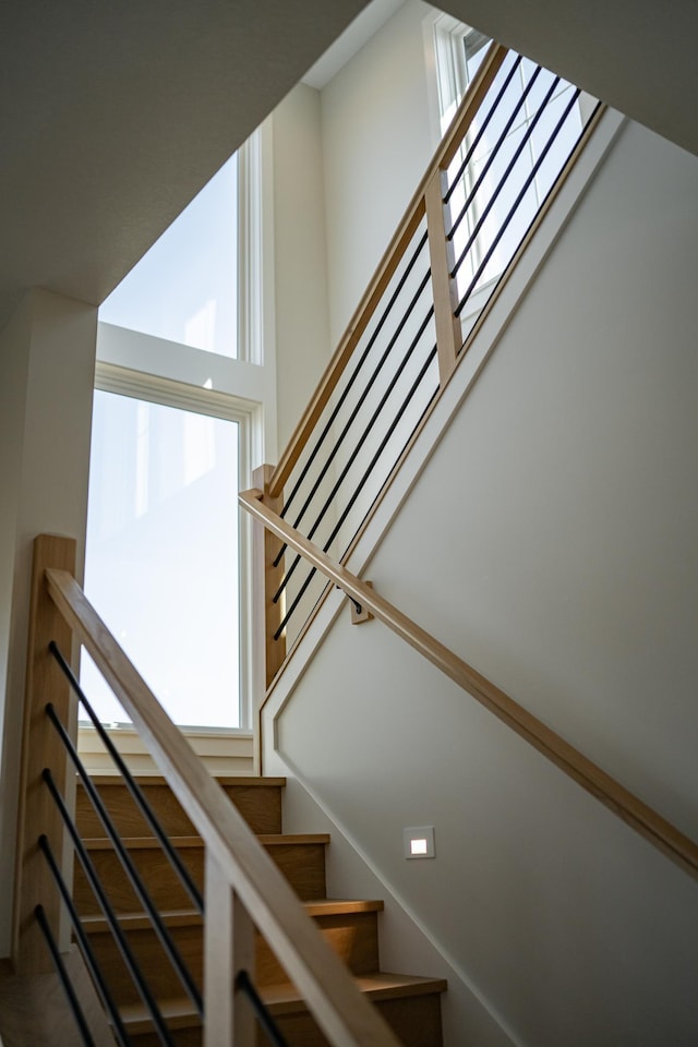 stairs featuring a towering ceiling and a wealth of natural light