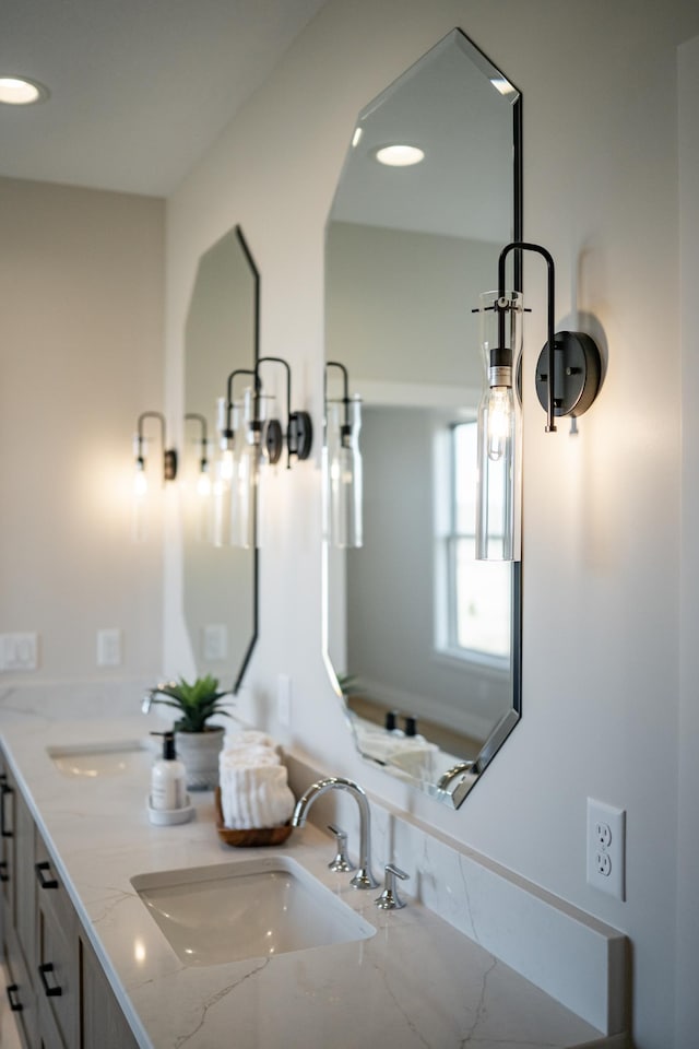 bathroom featuring a sink, recessed lighting, and double vanity