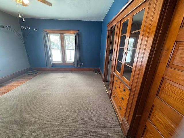 empty room featuring dark colored carpet and ceiling fan