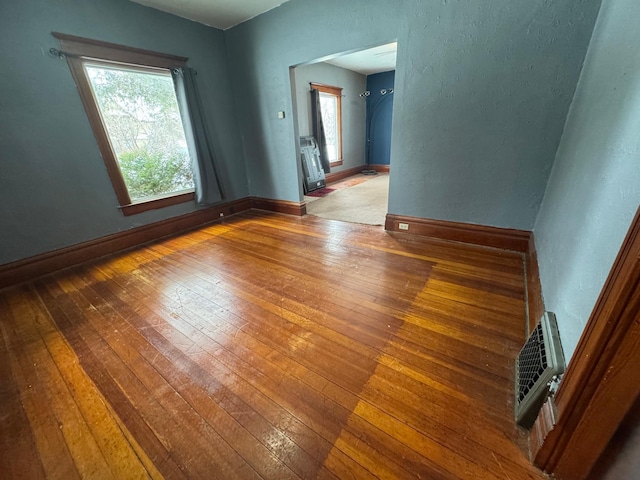 spare room featuring hardwood / wood-style flooring and a healthy amount of sunlight