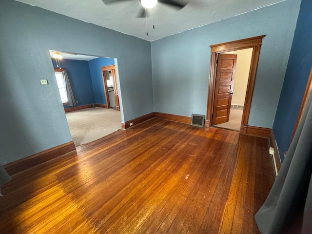 empty room with ceiling fan and dark hardwood / wood-style floors