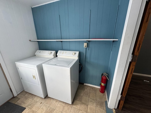 laundry area with independent washer and dryer and wooden walls