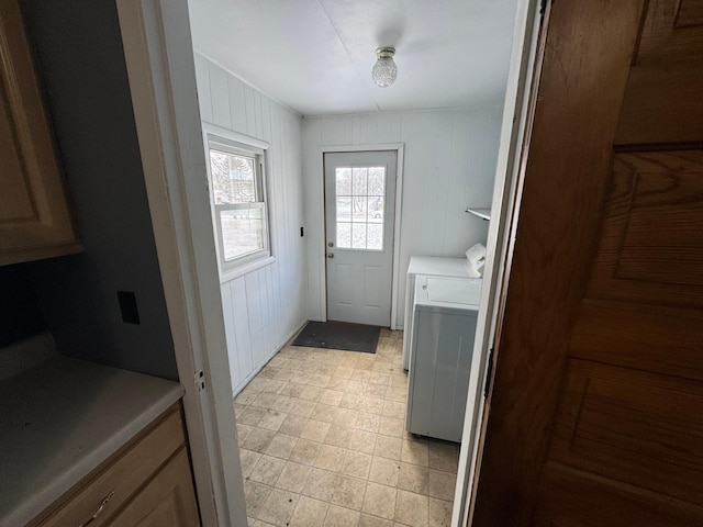 clothes washing area featuring wooden walls and washing machine and clothes dryer