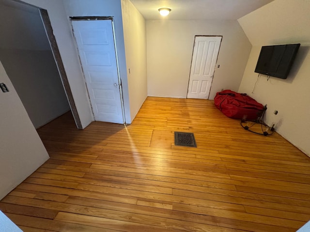 additional living space with light hardwood / wood-style flooring