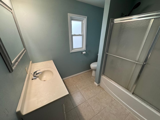 full bathroom with tile patterned flooring, vanity, bath / shower combo with glass door, and toilet