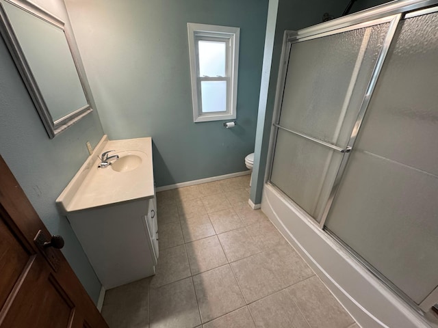 full bathroom featuring tile patterned floors, vanity, bath / shower combo with glass door, and toilet