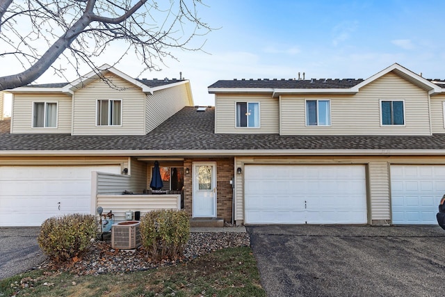 view of front of property featuring central AC unit and a garage