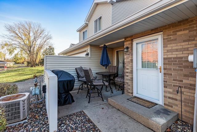 view of exterior entry featuring a patio area and central air condition unit