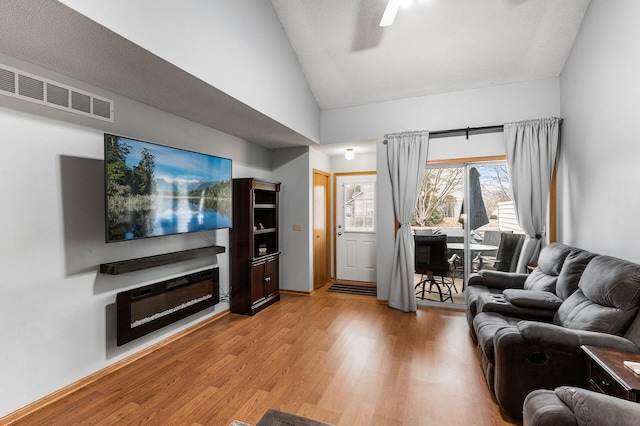 living room featuring high vaulted ceiling, wood-type flooring, and a textured ceiling