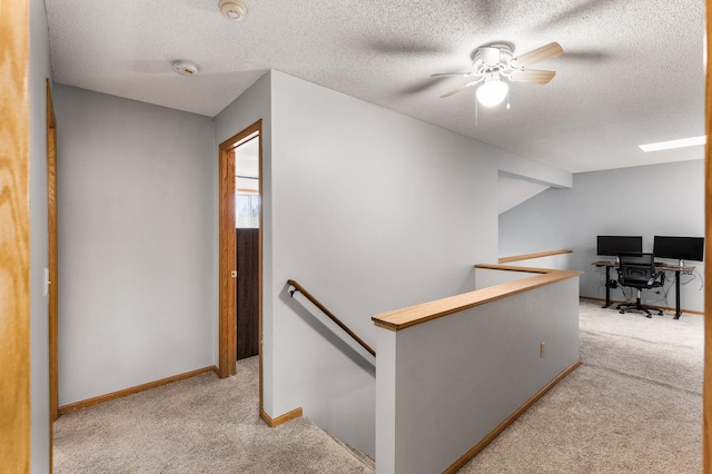 corridor with vaulted ceiling, light carpet, and a textured ceiling