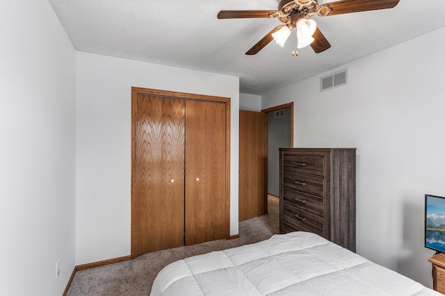 carpeted bedroom with ceiling fan, a textured ceiling, and a closet