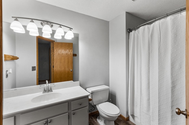 bathroom with hardwood / wood-style floors, vanity, a textured ceiling, and toilet