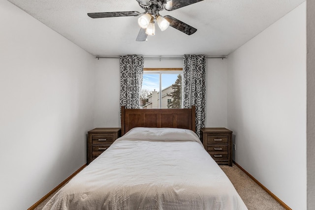 carpeted bedroom featuring ceiling fan and a textured ceiling