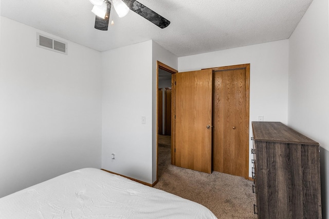 bedroom with ceiling fan, a closet, carpet floors, and a textured ceiling