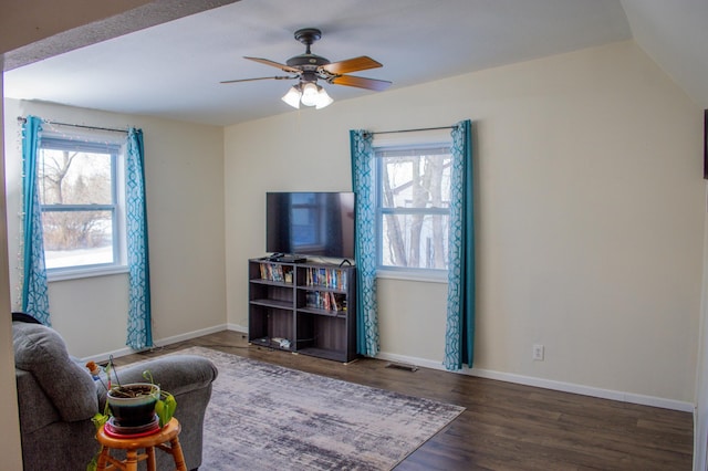 living room featuring ceiling fan, dark hardwood / wood-style flooring, and vaulted ceiling