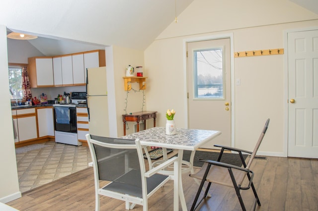 dining space featuring light hardwood / wood-style flooring and lofted ceiling