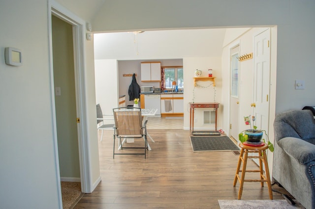 living room featuring light hardwood / wood-style flooring and vaulted ceiling