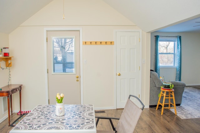 dining space featuring ceiling fan, wood-type flooring, and lofted ceiling