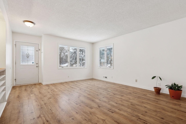 entryway featuring light wood-type flooring and a textured ceiling