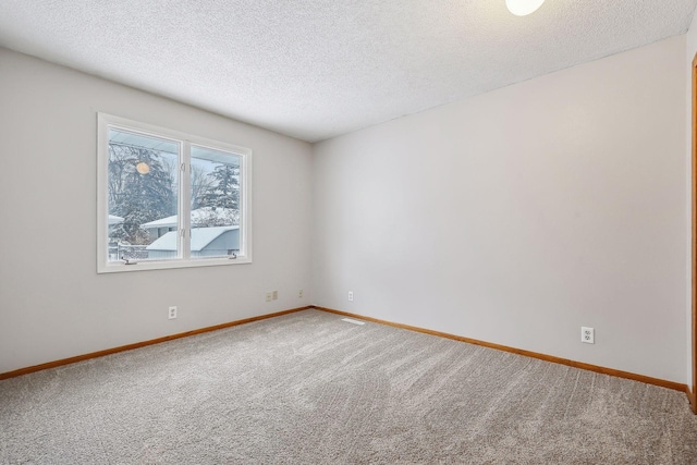 carpeted spare room with a textured ceiling